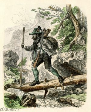 Jäger mit erbeuteter Gams überquert einen Bach in den Bergen